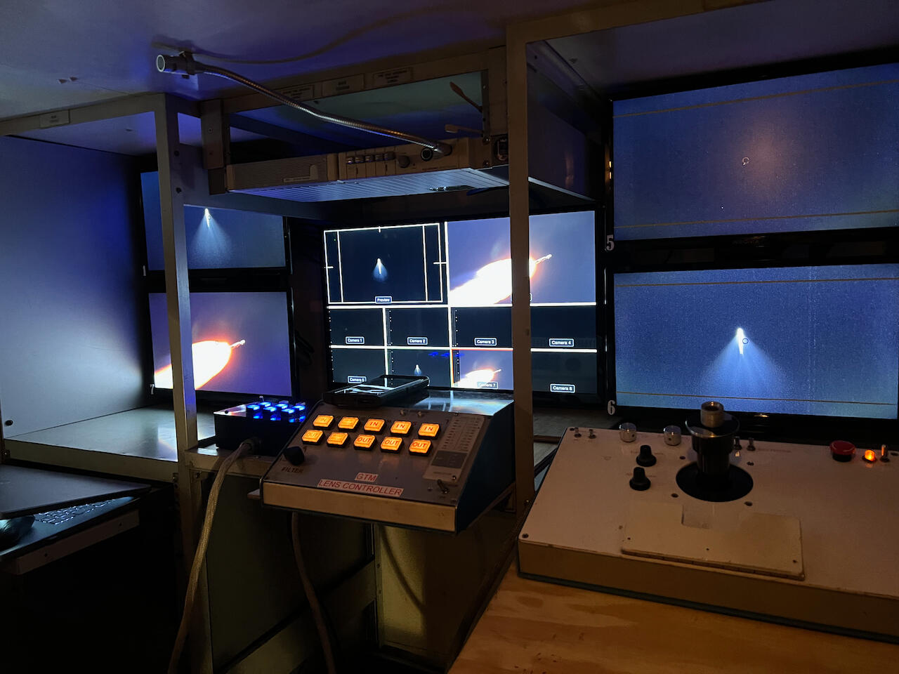 A control center with multiple TVs showing a rocket launch